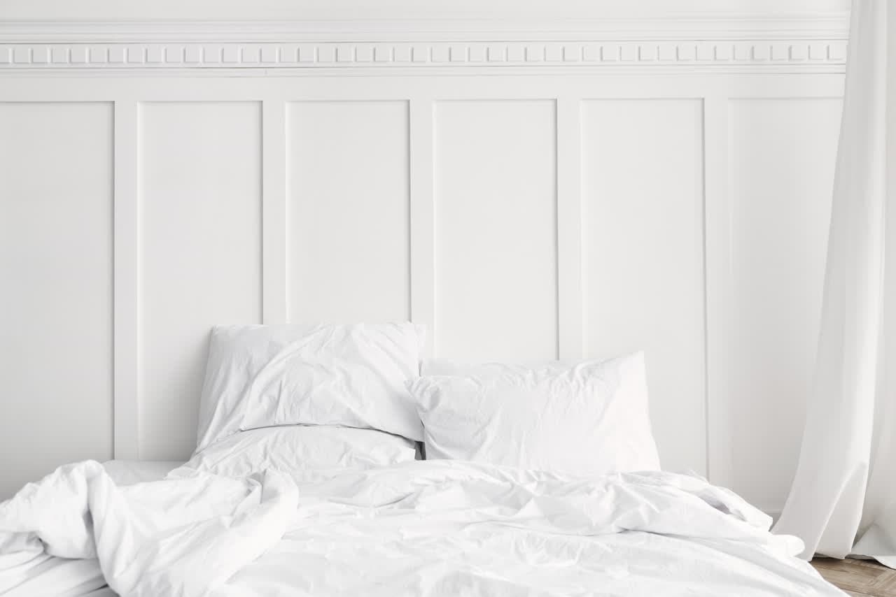 Cama con ropa de cama blanca de algodón puro en un dormitorio de Lugo