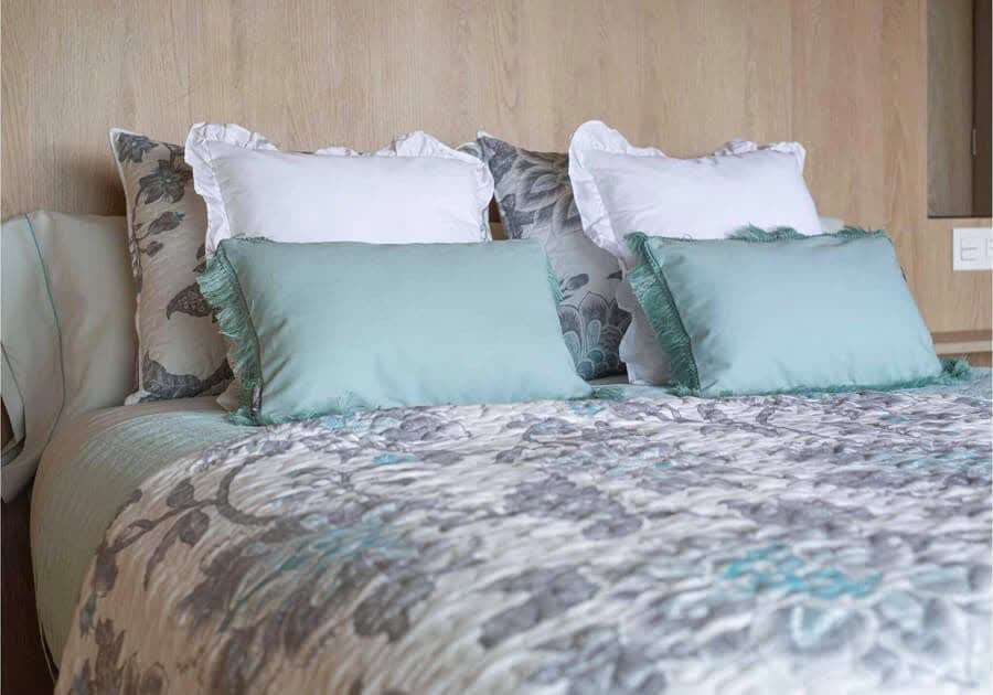 Cama vestida con colcha y cojines de ropa de cama de Modhogar en Lugo